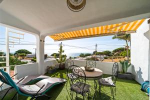 a patio with a table and chairs on a balcony at Casa Gudrun in Praia do Carvoeiro