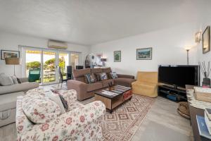a living room with couches and a flat screen tv at Casa Gudrun in Praia do Carvoeiro
