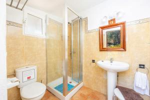 a bathroom with a shower and a toilet and a sink at Es Porcho in Deia +20 photos