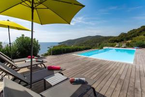 a patio with a swimming pool and an umbrella at Les Hauts de Figha in Conca