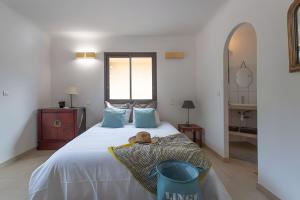 a bedroom with a large white bed with blue pillows at Les Hauts de Figha in Conca +22 photos