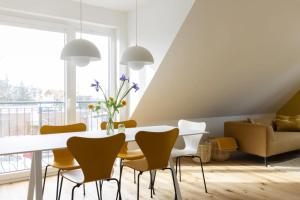 a dining room with a white table and yellow chairs at Strand in Böhl +32 photos