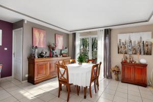 a dining room with a white table and chairs at Chambres d'Hôtes - Les Boubous in Saint-Nazaire +25 photos