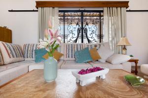 a living room with a couch and a vase with flowers on a table at Casa Glory in Antigua