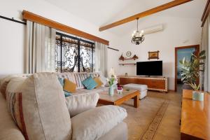 a living room with a couch and a tv at Casa Glory in Antigua