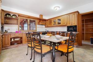 a kitchen with wooden cabinets and a table with chairs at Casa Glory in Antigua