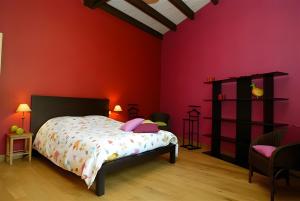 a bedroom with red walls and a bed with pink pillows at La Campagne in Saint-Hubert