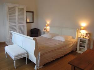 a bedroom with a white bed and a chair at La Campagne in Saint-Hubert +16 photos