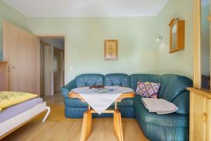 a living room with a blue couch and a table at Haus Grün in Templin