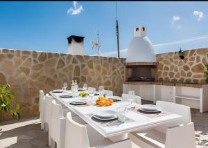a white dining table with white chairs in a kitchen at Villa Can Marsa in Santa Eularia des Riu