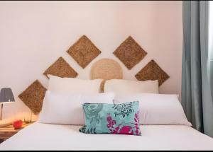 a bedroom with a white bed with a large headboard at Villa Can Marsa in Santa Eularia des Riu +16 photos