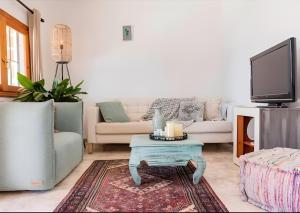 a living room with a couch and a tv at Villa Can Marsa in Santa Eularia des Riu