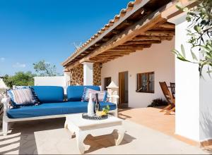 a living room with a blue couch on a patio at Villa Can Marsa in Santa Eularia des Riu