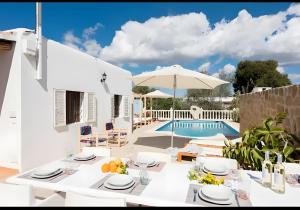 a villa with a swimming pool and a table and chairs at Villa Can Marsa in Santa Eularia des Riu