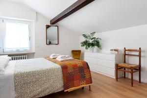 a bedroom with a bed and a chair and a mirror at The View in Levico Terme