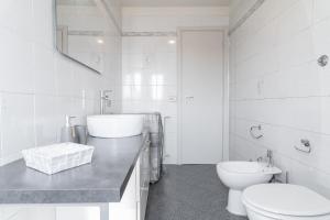 a white bathroom with a toilet and a sink at La Corte Rurale con jacuzzi in Lucca +13 photos