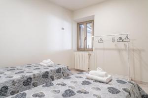 two beds in a white room with towels on them at La Corte Rurale con jacuzzi in Lucca