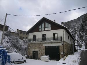 a house with a car parked in the snow at Kabila Enea 1 in Uztárroz