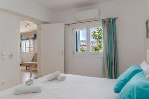 a white bedroom with a bed with towels on it at Afroditi Ftelia Gerani A in Mykonos