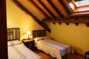 a bedroom with two beds and a ceiling at Kabila Enea 1 in Uztárroz
