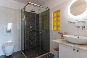 a bathroom with a glass shower and a sink at Afroditi Ftelia Gerani A in Mykonos +14 photos