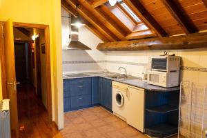 a kitchen with blue cabinets and a microwave at Kabila Enea 1 in Uztárroz