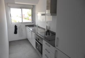 a kitchen with white cabinets and a window in it at Fantastic apartment in Torrevieja
