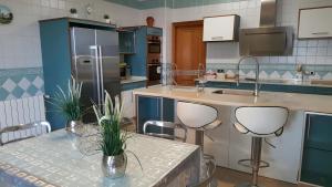 a kitchen with blue cabinets and a table with chairs at Casa las Columnas in Capdepera