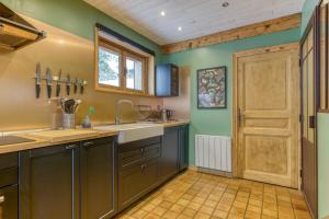 a kitchen with green walls and a wooden door at Le Flocon Grand Chalet 4 étoiles in Villard-Reculas