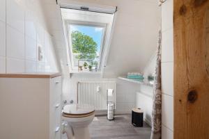 a white bathroom with a toilet and a window at Harmonie Wohnung in Oyten +22 photos