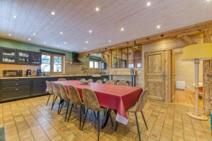 a large kitchen with a red table and chairs at Le Flocon Grand Chalet 4 étoiles in Villard-Reculas