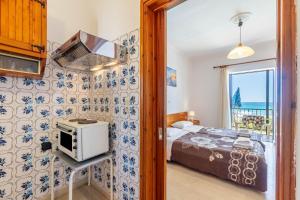 a small bedroom with a bed and a microwave at Mires House Front Studio 1 in Agios Gordios