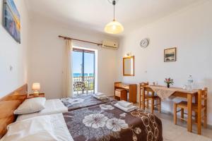 a bedroom with a bed and a table and a window at Mires House Front Studio 1 in Agios Gordios
