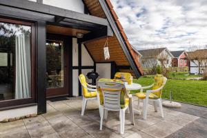 a patio with a table and yellow chairs at Ferienhaus Elbidylle in Bachenbrock