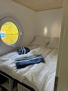 a bed in a small room with a window at Hausboot Kitilou in Flessenow