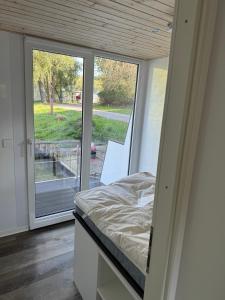 a bedroom with a bed and a sliding glass door at Hausboot Kitilou in Flessenow +5 photos