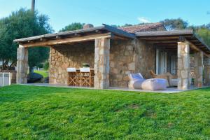 a stone house with a pavilion in a yard at Petra d'arana in Palau +29 photos