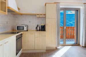 a small kitchen with a microwave and a window at Oberhemberger Hof Feldthurns in Feldthurns