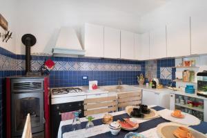 a kitchen with white cabinets and a stove top oven at Oasi in Alassio