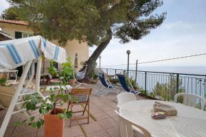 a patio with a table and chairs and the ocean at Oasi in Alassio