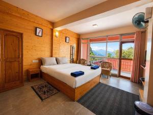 a bedroom with a bed and a large window at Shikher Guest House in Kalimpong