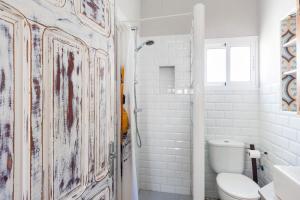 a white bathroom with a toilet and a shower at Casa Basallote in El Palmar +17 photos