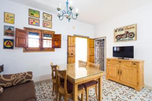 a living room with a dining room table and a tv at Casa Basallote in El Palmar