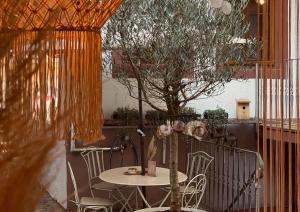 a table and chairs with a tree in a room at Heart Ferienwohnungen Frida I Kahlo in Vogtsburg