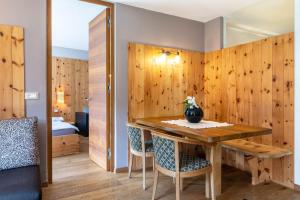 a room with a wooden wall with a table and chairs at La Plates App Domesdi in Ortisei +15 photos