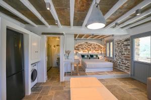 a bedroom with a bed and a brick wall at Celini Villas Tinos in Tinos