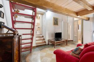 a living room with a red couch and a television at Antro Di Circe - Orta Centro in Orta San Giulio