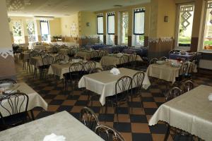 a dining room with tables and chairs with white tablecloths at OW Posejdon Dźwirzyno in Dźwirzyno