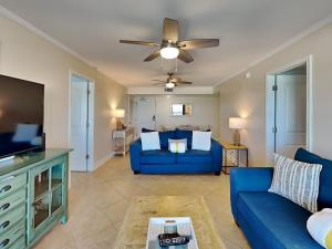 a living room with a blue couch and a tv at Regency Towers #802 East in Pensacola Beach +27 photos