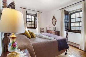 a bedroom with a bed with a lamp on a table at Casa do Adro do Soajo in Soajo